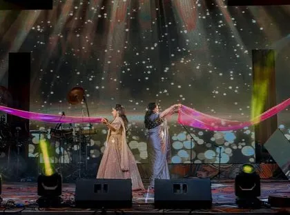 A graceful family performance using dupattas as props against a starry night backdrop.