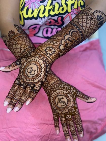 A stylish pose showing off a design with the couple's initials, 'AS', and wedding rings, each in a decorative floral mandala.