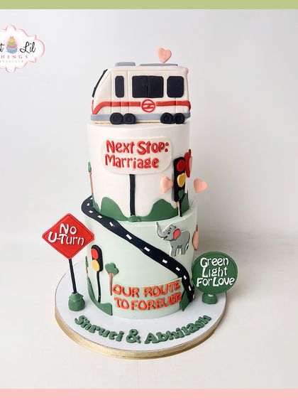A whimsical wedding cake celebrating a "Route to Forever." This tiered cake tells a love story with details like a Delhi Metro train, traffic signs, and a "Green Light for Love."
