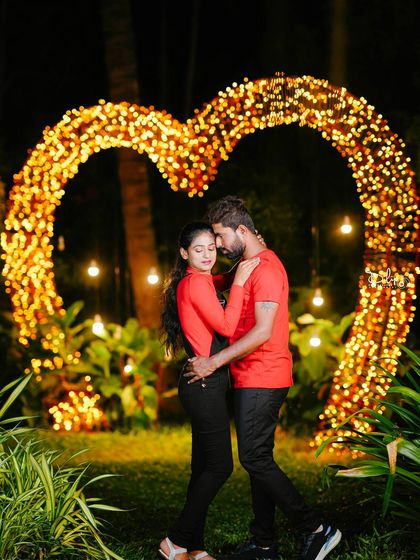 An intimate moment in front of the glowing heart prop, perfect for a romantic night-time shoot.
