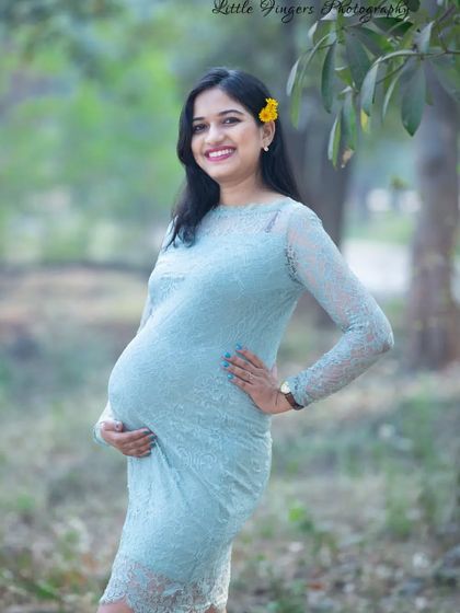 A confident and happy portrait in a light blue lace dress. The pop of a yellow flower in her hair adds a cheerful, sunny touch to the photo.