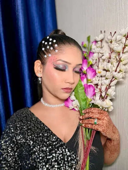 A portrait of the model holding flowers, showcasing the complete dramatic and creative makeup look.