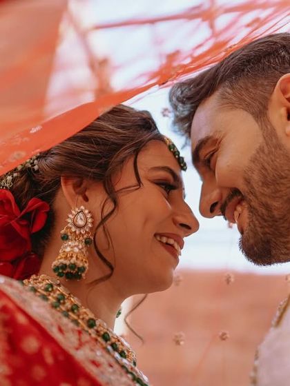 A joyful and candid moment under the veil, with the couple sharing a laugh.