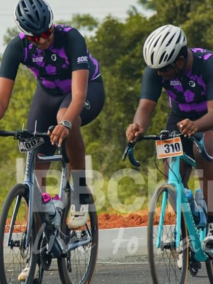 Two riders from the same team work together during a Criterium race. Team tactics are crucial in these fast-paced, technical events.