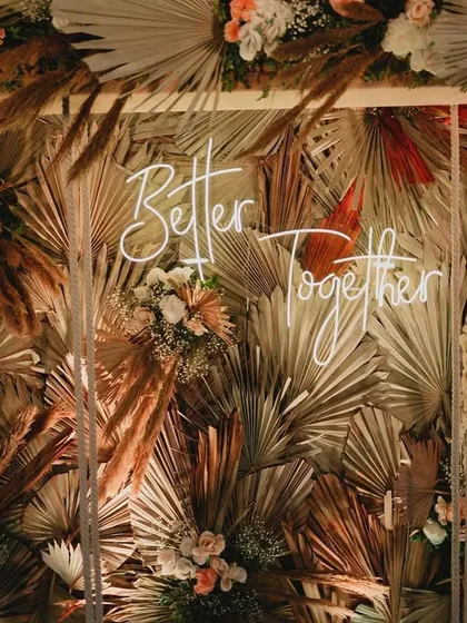A close-up of our 'Better Together' swing photo-op, showing the rich texture of the dried palm leaves and pampas grass.