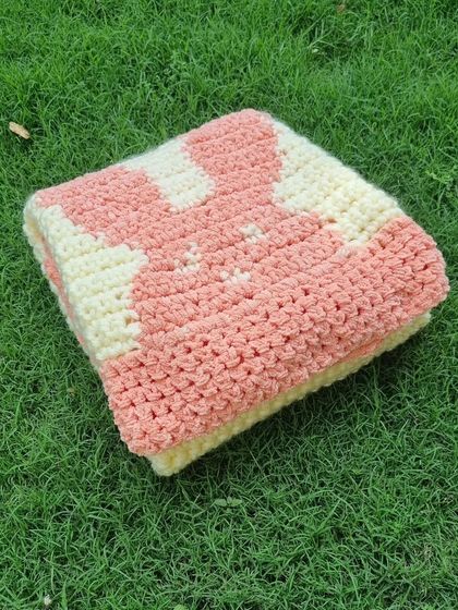 The blanket folded to show the cute bunny design. The combination of cream and soft pink is so gentle and classic for a baby item.