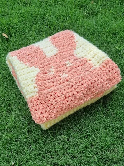 The blanket folded to show the cute bunny design. The combination of cream and soft pink is so gentle and classic for a baby item.