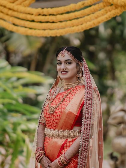 A full-length view of Tanu's muhurtham look, complete with a delicate veil and traditional temple jewellery.
