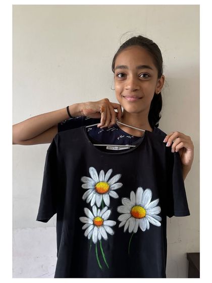 An 8th-grade student displays the beautiful daisy T-shirt she painted. In my fabric painting classes, older students can learn more advanced techniques to create professional-looking designs.