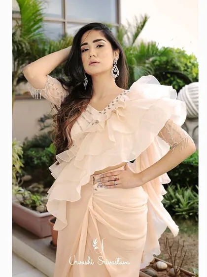 A full-length shot of the modern ruffle saree look. The makeup is kept soft and elegant to balance the dramatic silhouette of the outfit, ensuring a harmonious and stylish final image for the designer's lookbook.