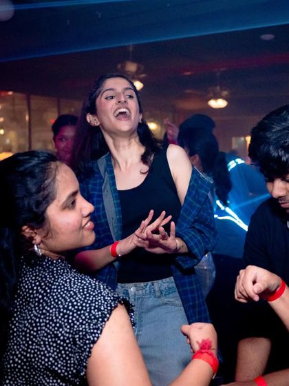 Pure, uninhibited joy. A partygoer singing her heart out on the dance floor.