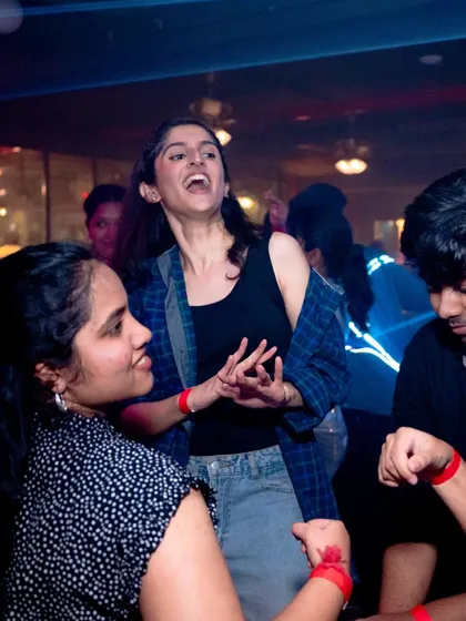 Pure, uninhibited joy. A partygoer singing her heart out on the dance floor.
