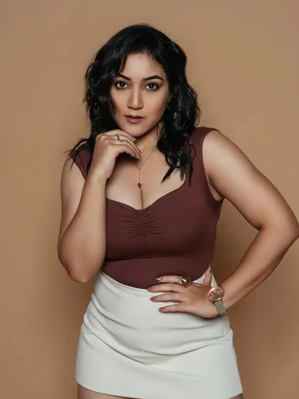 A confident and powerful pose. The soft glam makeup enhances her features without being distracting, creating a polished and professional look.