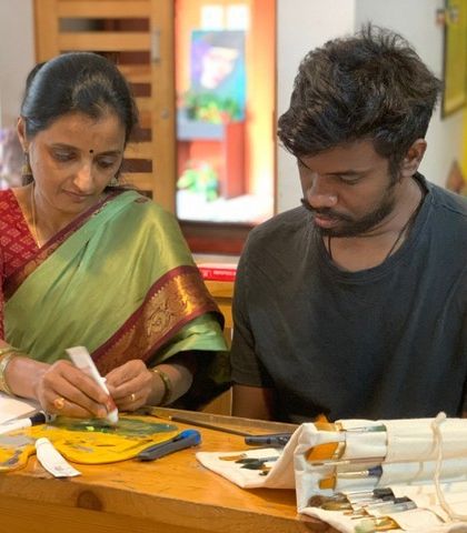 I demonstrate a technique using a masking fluid pen to a student. We introduce various tools and materials, ensuring our students have a well-rounded understanding of their chosen medium.