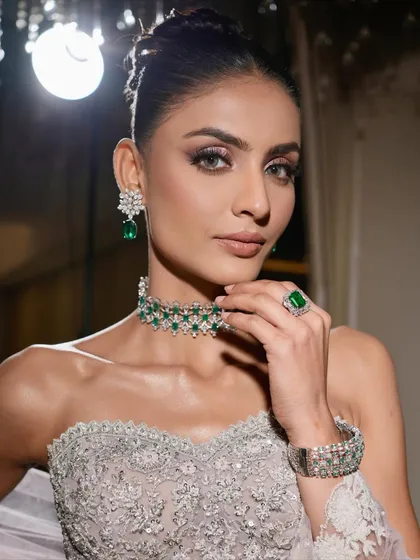 This is modern elegance with an edge. I created this sculpted glam look with shimmering silver and lilac eyeshadow, flawless skin, and bold brows, perfectly complemented by a stunning emerald and diamond choker for a high-fashion, reception-ready finish.