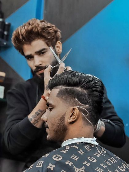 Hair game strong. This action shot shows me creating a detailed razor design with scissors, showcasing precision and artistry.