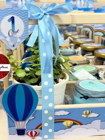 A close-up of the 'Hot Air Balloon' basket, showing the polka-dot ribbon, themed cutout, and "One" tag.