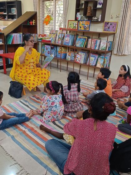 The storyteller pauses to ask the children a question, encouraging participation. This interactive method is key to our philosophy of active learning and engagement.