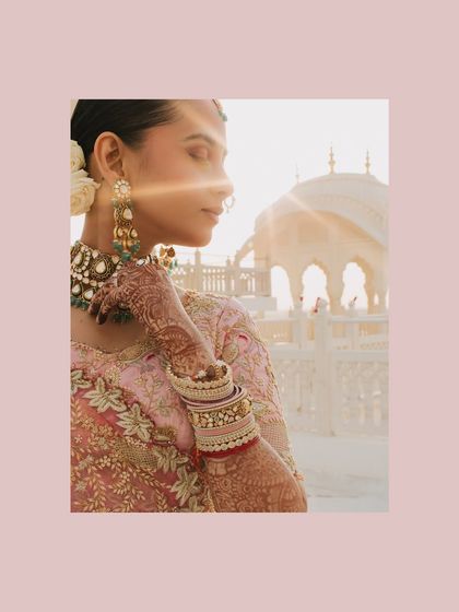 A sun-kissed portrait of Shreya in Jaipur, focusing on the details of her henna and bangles. The golden light and the architectural backdrop add to the royal and romantic feel of this destination wedding shot.