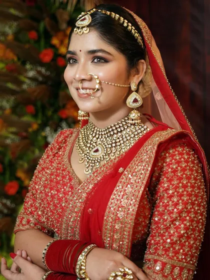 A side profile capturing the elegance of the bride. The makeup is designed to complement her features and the heavy jewelry without overpowering her natural beauty.