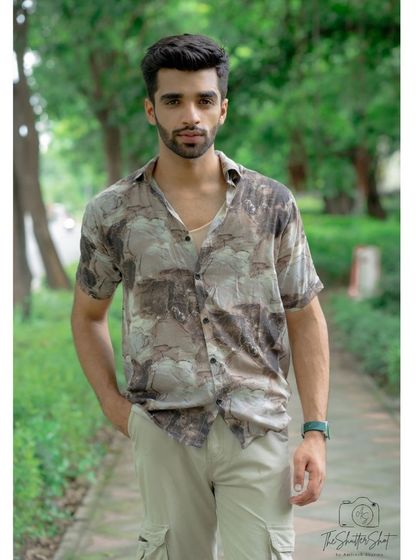 A straight-on shot of a model in a casual printed shirt and cargo pants. This portrait captures a direct and engaging look, ideal for a social media profile or casting headshot.