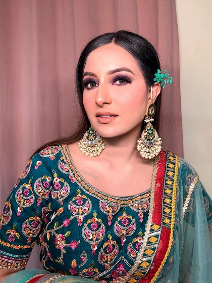 A closer look at this purple smokey eye look, perfectly complemented by a simple but effective green floral hairpiece.