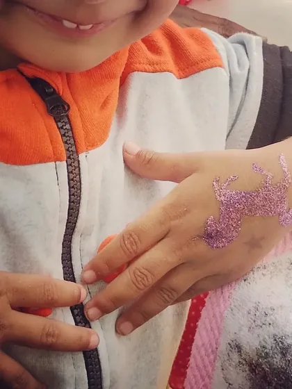 A cute, small unicorn glitter tattoo on the hand of a young party guest. Even a little bit of sparkle can make a big impression.