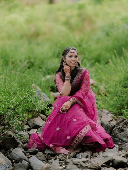 A beautiful, relaxed portrait of the bride-to-be sitting among the rocks and greenery, looking thoughtful and serene.