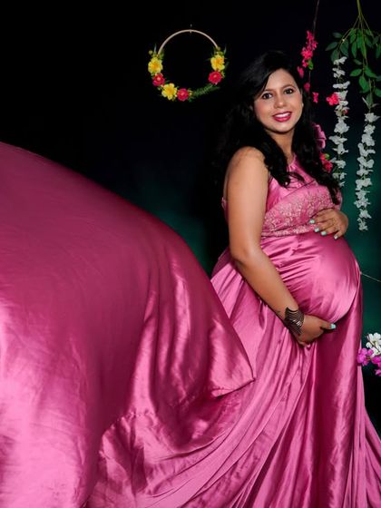 A dynamic studio shot capturing the movement of a satin pink gown. This technique adds energy and a high-fashion feel to the solo maternity portrait.