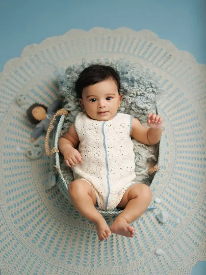 Four months of wonder. This baby boy looks so calm and curious in a blue-themed setup, showing how I use color and texture to create beautiful, composed milestone portraits.