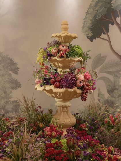 A three-tiered fountain overflowing with flowers and fruits, a central feature of the 'Orchard of Life' naming ceremony.