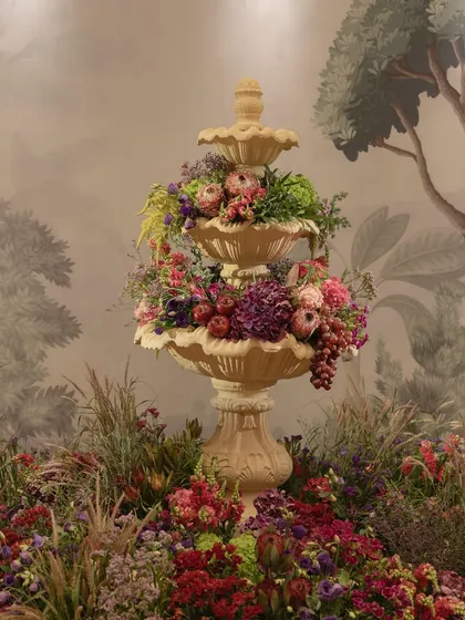 A three-tiered fountain overflowing with flowers and fruits, a central feature of the 'Orchard of Life' naming ceremony.