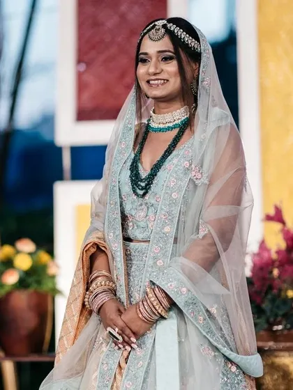 A beautiful bride at her pre-wedding ceremony. The backdrop features colorful panels and floral arrangements, adding a festive touch to her portraits.