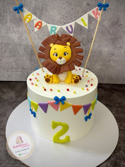Roar! A sweet lion-themed cake for little Aarvik's 2nd birthday. The friendly fondant lion sits atop a cake decorated with a colourful bunting, ready for the party.