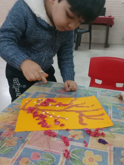 A close-up of the finished blossom art. The use of different colored crumpled paper adds depth and realism to the branches, creating a beautiful piece of spring-themed art.