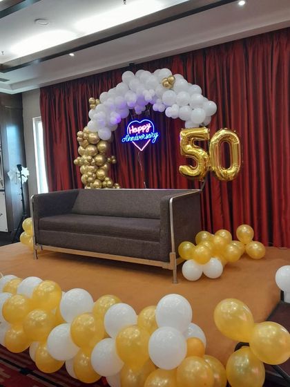 A final look at the golden anniversary stage, ready for the celebration. The combination of balloons, neon lights, and foil numbers creates a grand and festive look.