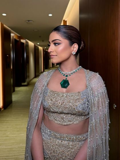 A side profile showing the clean bun and the beautifully sculpted cheekbones. A timeless and sophisticated look.