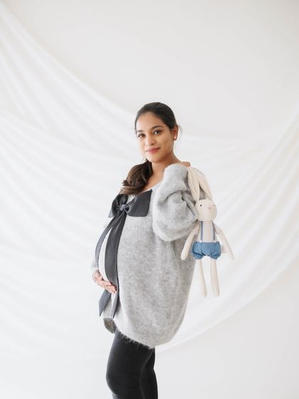 A sweet and casual portrait, with the mother-to-be holding a stuffed animal, ready to welcome her little one.