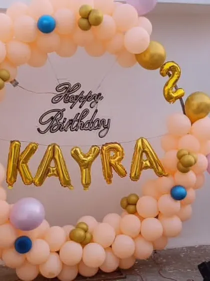A lovely pastel-colored ring decoration for Kayra's second birthday. This outdoor setup uses a full balloon circle with the name in gold foil letters, perfect for a terrace or garden party.