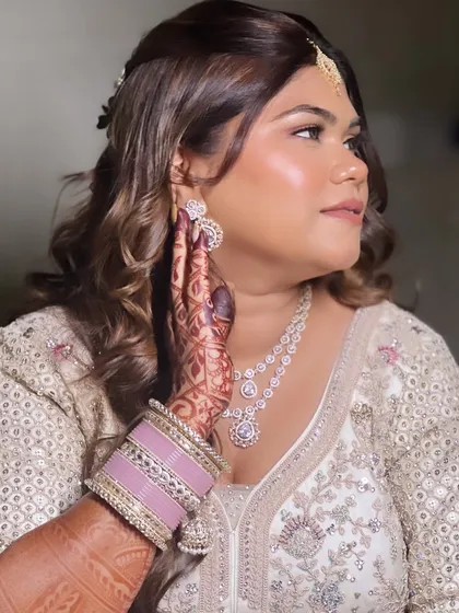 A stunning bride in a white lehenga for her engagement. The makeup is glamorous and sophisticated, with a focus on her beautiful eyes.