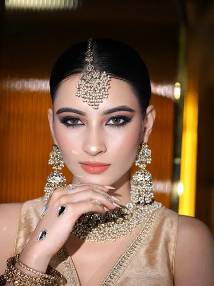 A close-up of the makeup for this look. Notice the sharp winged liner, defined brows, and matte nude lip.