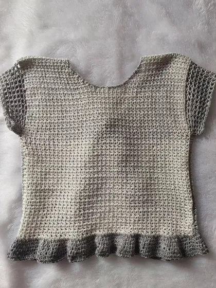 A flat-lay of the back of the Orchid Top, showing the solid back panel and mesh sleeves.