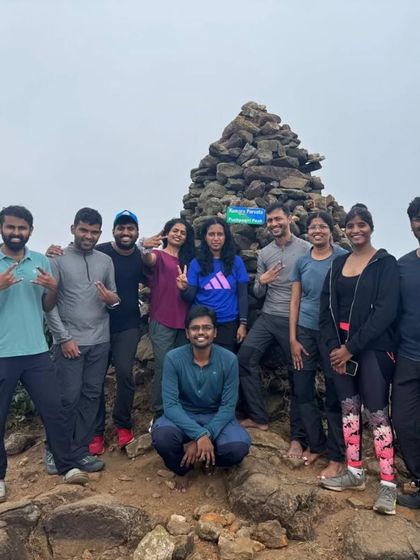 The victorious group at the Kumaraparvatha summit, marked by a pile of stones. Conquering this peak together is an incredible bonding experience.