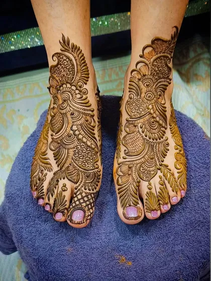 Complete your festive attire with intricate henna for your feet. This Arabic-inspired foot mehandi features a detailed paisley and floral pattern that covers the top of the foot, creating an elegant and complete look.