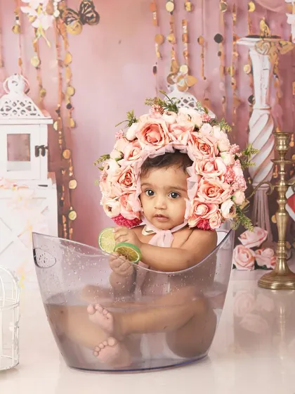 A creative milk bath style shoot for a 9-month-old, featuring a floral headpiece and a playful vibe.
