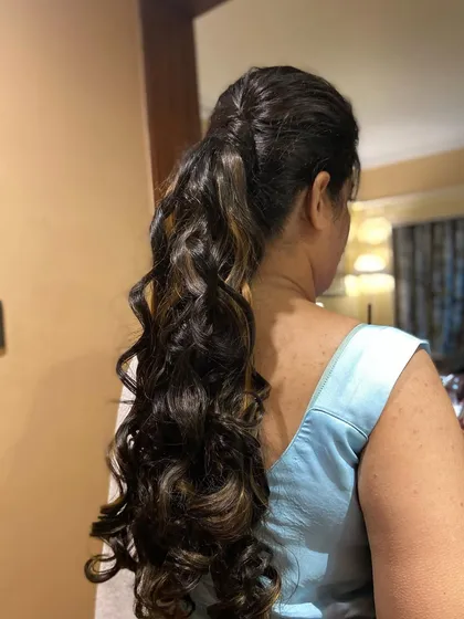 A chic and stylish curly ponytail. This is a great option for keeping hair off the face while still looking glamorous.