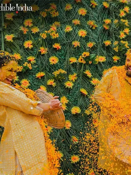 A moment of pure, infectious laughter as the couple playfully throws marigold petals at each other during their Haldi in Jaipur.