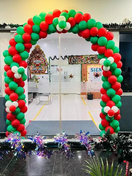 A festive balloon arch in classic red and green for a corporate office Christmas celebration. This decoration creates a welcoming entrance for employees and visitors during the holiday season.