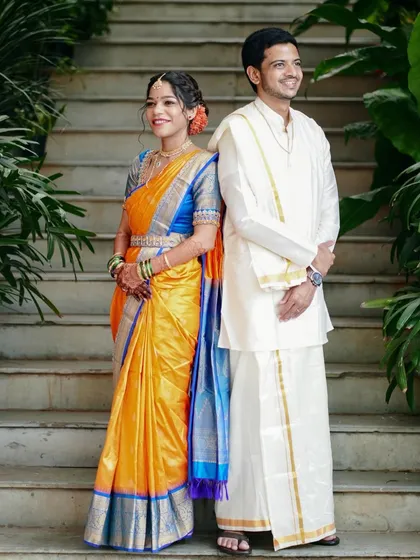 A charming back-to-back pose on the stairs. This portrait is playful yet poised, showcasing the couple's style and connection.