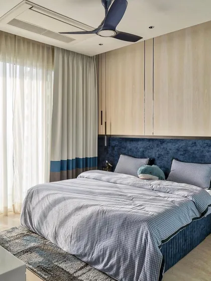 An eclectic room for a 10-year-old boy, using a calming blue and white colorway. The design is light and airy, with a custom bed and subtle patterns that add a touch of whimsy without being childish.